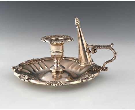 An early Victorian silver chamberstick, with fluted circular base bordered by flowers, foliage, and scrolls, the C-scroll han