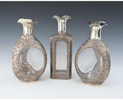 China.Three Chinese silver overlay decanters, the casements of each pierced and decorated with dragons, marked to the undersi
