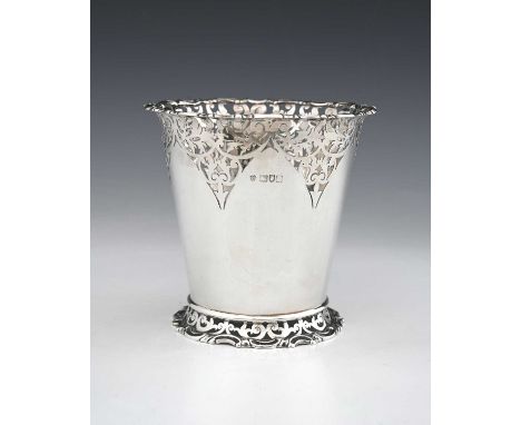 A George V silver vase or bottle holder, of tapered cylindrical form, with pierced scroll decoration, atop a flared pierced f