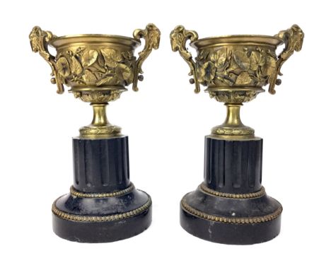 PAIR OF LATE 19TH CENTURY GARNITURES, of urn form, cast in relief with floral decoration, with twin ram's head handles, on bl