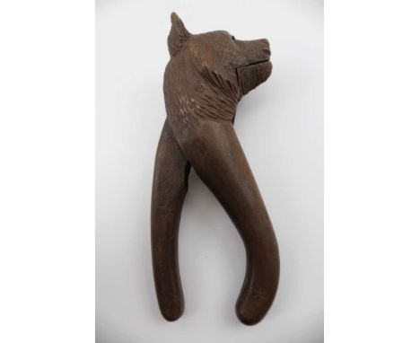 A BLACK FOREST CARVED WOOD NOVELTY LEVER ACTION NUTCRACKER, carved as a head of a bear, 16cm. There is definitely one eye mis