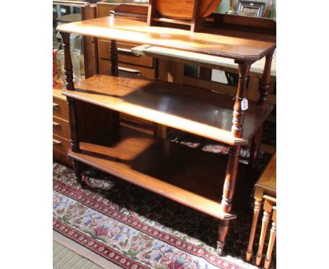 A LATE VICTORIAN MAHOGANY THREE-TIER BUFFET, moulded upstand to back, the canted tiers separated by ring turned and baluster 