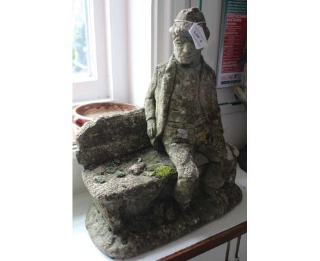 A CAST CONCRETE GARDEN ORNAMENT OF A GENTLEMAN ON A BENCH 