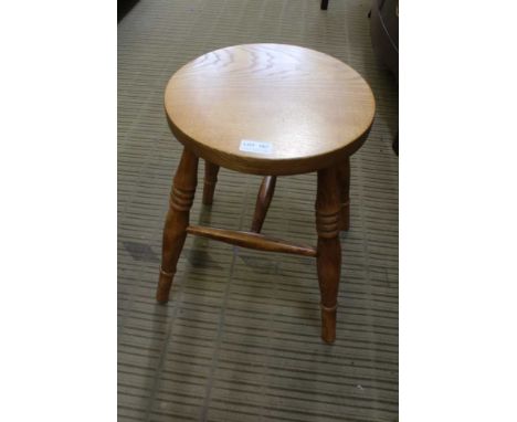 A MODERN ELM CIRCULAR TOPPED FOUR LEGGED STOOL 