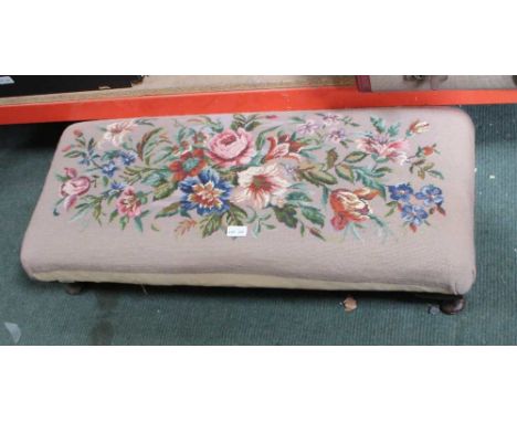 A LARGE RECTANGULAR FLORAL WOOLWORK PAD TOPPED STOOL 