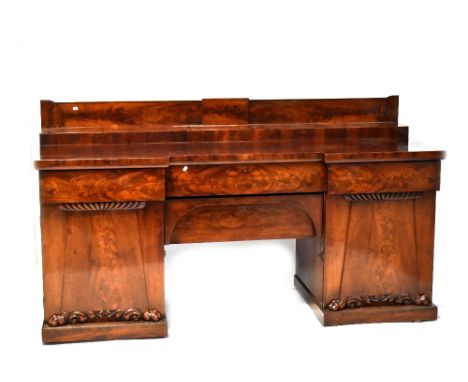 An early Victorian flame mahogany pedestal buffet sideboard of large proportions, the galleried top with raised back section,