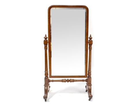 A Victorian mahogany cheval mirror, the rectangular plate on carved and turned supports united by a stretcher and on outswept
