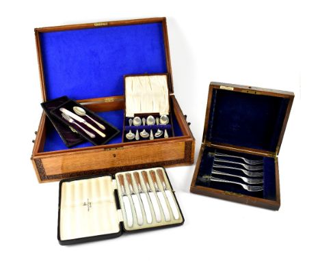 An oak cutlery box with carved Oriental junk to the centre and a small quantity of cased plated flatware to include a set of 