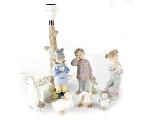 A Nao figural table lamp in the form of a young girl with satchel on her back and dog at her feet, the lamp fashioned as a tr