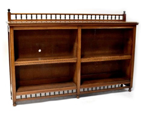 A late Victorian walnut freestanding bookcase with bobbin turned gallery above two sections, each with four shelves and on tu