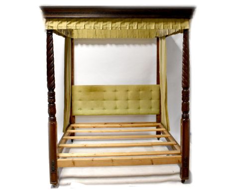 A mahogany four-poster bed with a dentil moulded open canopy, on a pair of wythen turned columns with carved acanthus leaf de