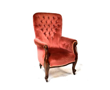 A Victorian mahogany button-back armchair upholstered in pink velour and with scroll ends, on cabriole legs with castors. CON