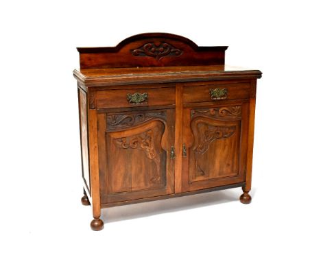 An Art Nouveau sideboard with carved gallery to top, two short drawers and two carved cupboard doors on bun feet, 121 x 119 x