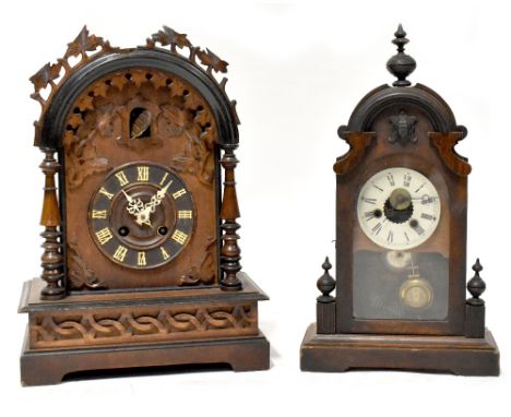 A Black Forest cuckoo clock, the arched cased with carved ivy leaf detail, the dial set with Roman numerals, on rectangular b