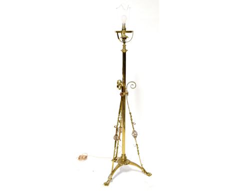 An Arts and Crafts brass standard lamp with applied copper decoration, on tripartite base with paw feet, height 130cm.