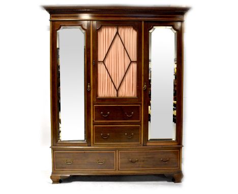 An Edwardian inlaid mahogany triple compactum wardrobe, the central section with glazed door above two short drawers flanked 