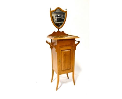 An Edwardian tile-top wash stand with shield-shaped mirror above a base of single cupboard door flanked by towel rails on out