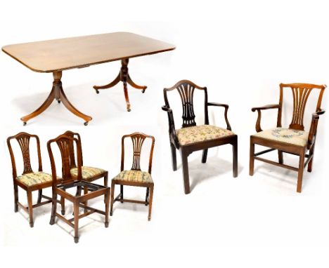 A Georgian-style mahogany dining table of rectangular form with rectangular corners, on twin pedestal bases with outswept leg