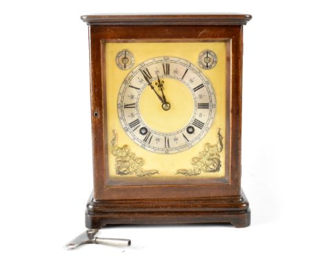 A 20th century mahogany-cased eight-day chiming mantel clock, the gilded dial with raised putti decoration, silvered chapter 