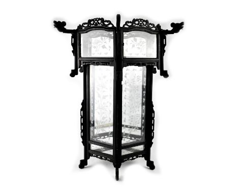 A Chinese ebonised wooden handing ceiling lantern with six etched glass panels depicting bamboo and peonies, within pierced c