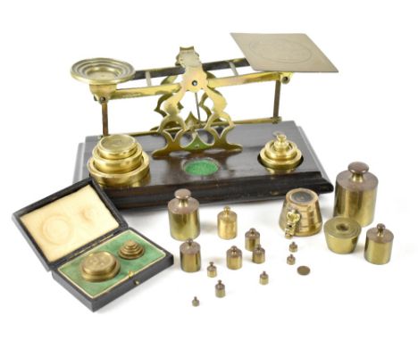 A set of late 19th/early 20th century brass inland postal letter scales on rectangular mahogany base, with a quantity of bras