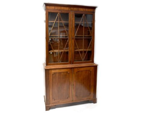 A 19th century mahogany bookcase, the top with a pair of astragal glazed doors, on a base with a pair of panelled doors, rais