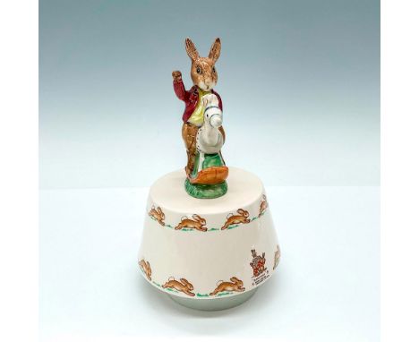 Adorable vintage music box featuring a bunny riding a rocking horse toy, dressed in a maroon sweater. The charming scene is s