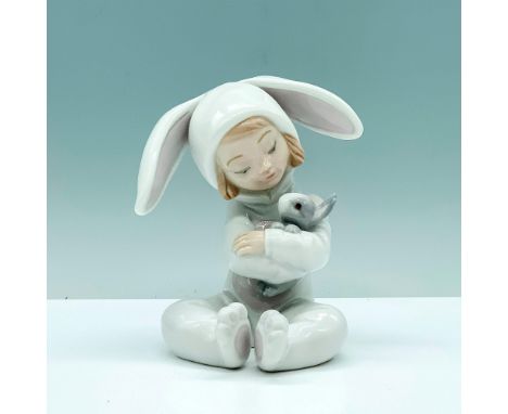 A glazed figure of a young child in a bunny pajama giving a hug to their pet rabbit. Lladro backstamp. Artist: Jose Javier Ma