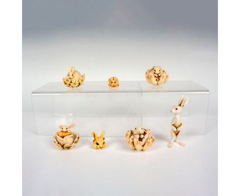 A set of 7 bunny theme items consisting of 4 round bunny figures that fit into a decorative base, a rabbit at rest, a rabbit 