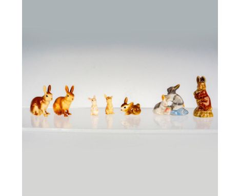 A delightful collection of seven ceramic rabbits with five in warm brown tones, one in pristine white, and another in a capti