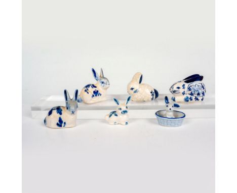 A set of 6 white and blue pottery rabbits that are decorated with floral designs, polka dots, or crackle glaze. Shab backstam
