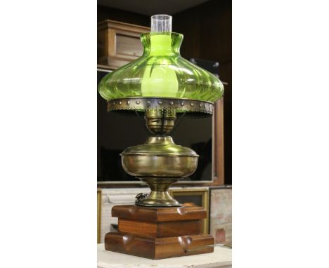 A Victorian tablelamp formed as a brass based oil lamp with green glass shade.