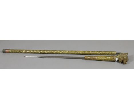 An eastern brass mounted sword stick with repousse work detail and a terminal formed as a mythical beast.