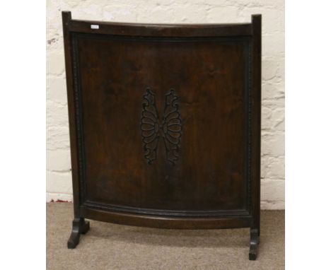 A carved oak bow shaped firescreen with applied fretwork.