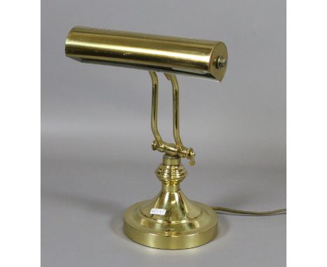 A brass based desk lamp.