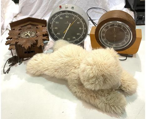 A Junghans Dark Room step clock; a cuckoo clock, another clock and a Steiff polar bear. 