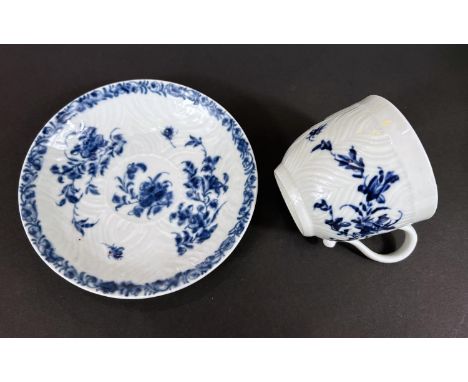 A First Period Worcester style porcelain in blue and white cup and saucer with floral decoration wave like texture to the bod