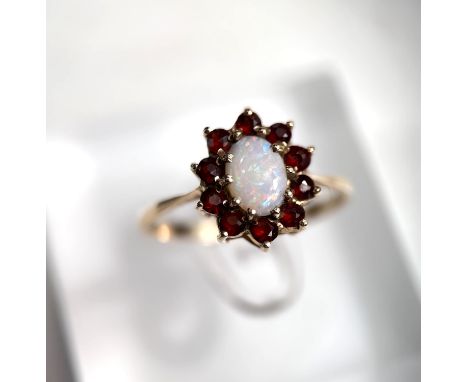 A 9 carat hallmarked gold ring set opal and garnet coloured stones, 2.1gm 