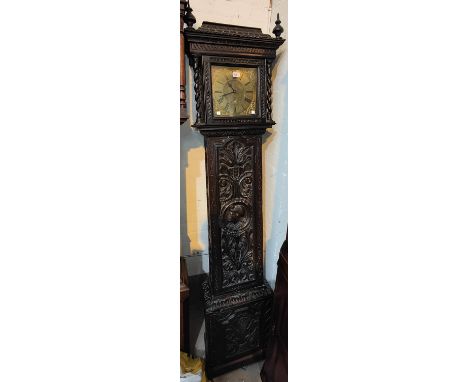 An 18th century oak longcase clock with later extensive carved decoration, barley twist side  columns to the hood, full lengt