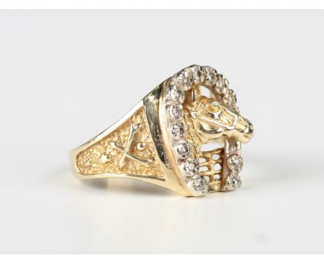 A gold and diamond ring, designed as a horse's head within a diamond set horseshoe shaped surround, with cast decoration to t