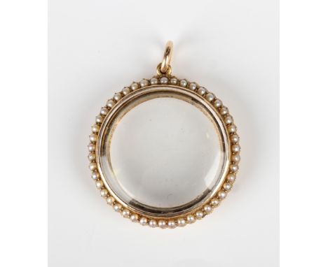 A gold and seed pearl circular pendant locket, glazed to the back and front, with a surround of seed pearls, unmarked, weight