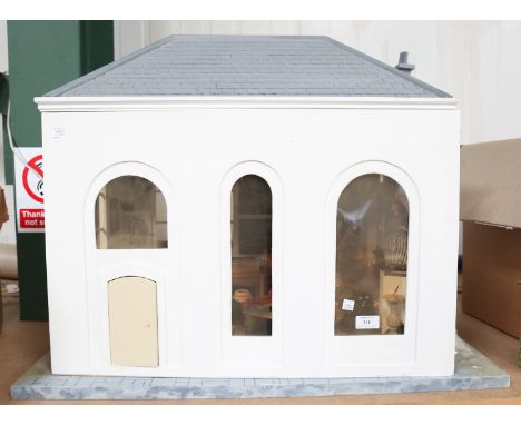 A modern single-storey doll's house/studio with pitched roof, the opening front revealing a room, height 63cm, width 80cm, de