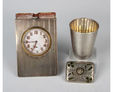 A George V silver mounted leather bedside timepiece with engine turned decoration, the folding leather cover forming a suppor