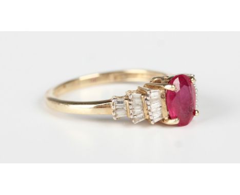 A 9ct gold ring, claw set with an oval cut ruby between baguette cut diamond set shoulders, weight 1.8g, ring size approx J.B