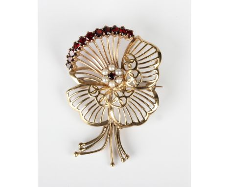 A 9ct gold, garnet and cultured pearl brooch, designed as a stylized pansy, London 1958, weight 7.8g, width 3.3cm.Buyer’s Pre