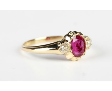 A gold, ruby and diamond ring, mounted with the oval cut ruby between two cushion cut diamonds, unmarked, weight 2.6g, ring s