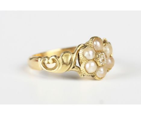 A Victorian gold, diamond and seed pearl cluster ring in a flowerhead shaped design with scroll pierced shoulders, unmarked, 