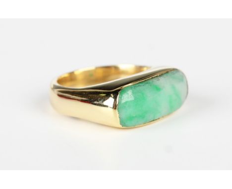 A gold and jade ring in a curved rectangular design, unmarked, weight 8.3g, ring size approx K1/2, with a case.Buyer’s Premiu