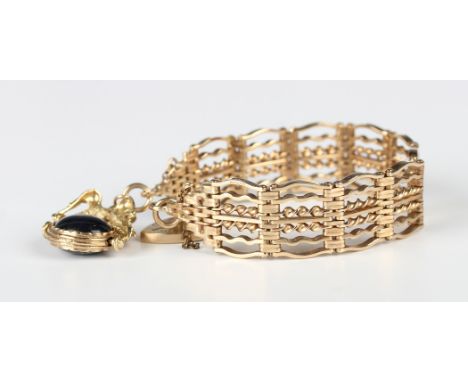A 9ct gold twisted bar and curved bar link gate bracelet on a 9ct gold heart shaped padlock clasp, with a 9ct gold mounted va