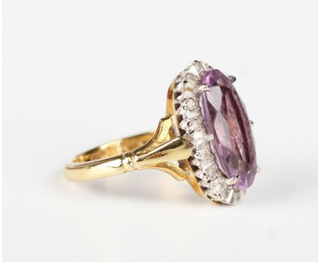 An 18ct gold, amethyst and diamond oval cluster ring, claw set with the oval amethyst within a surround of circular cut diamo